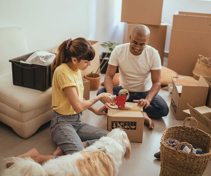 Couple taping moving boxes