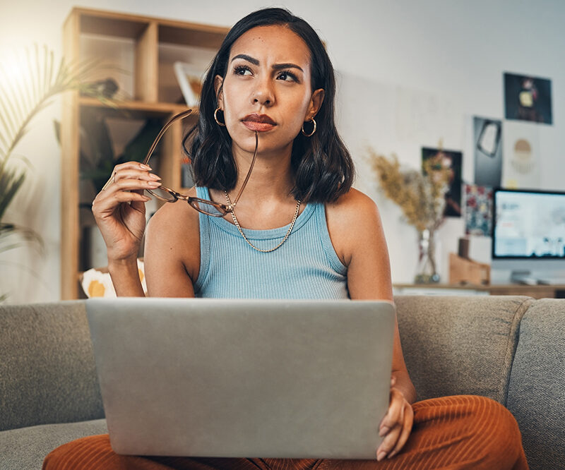 woman pondering a though while working on the computer